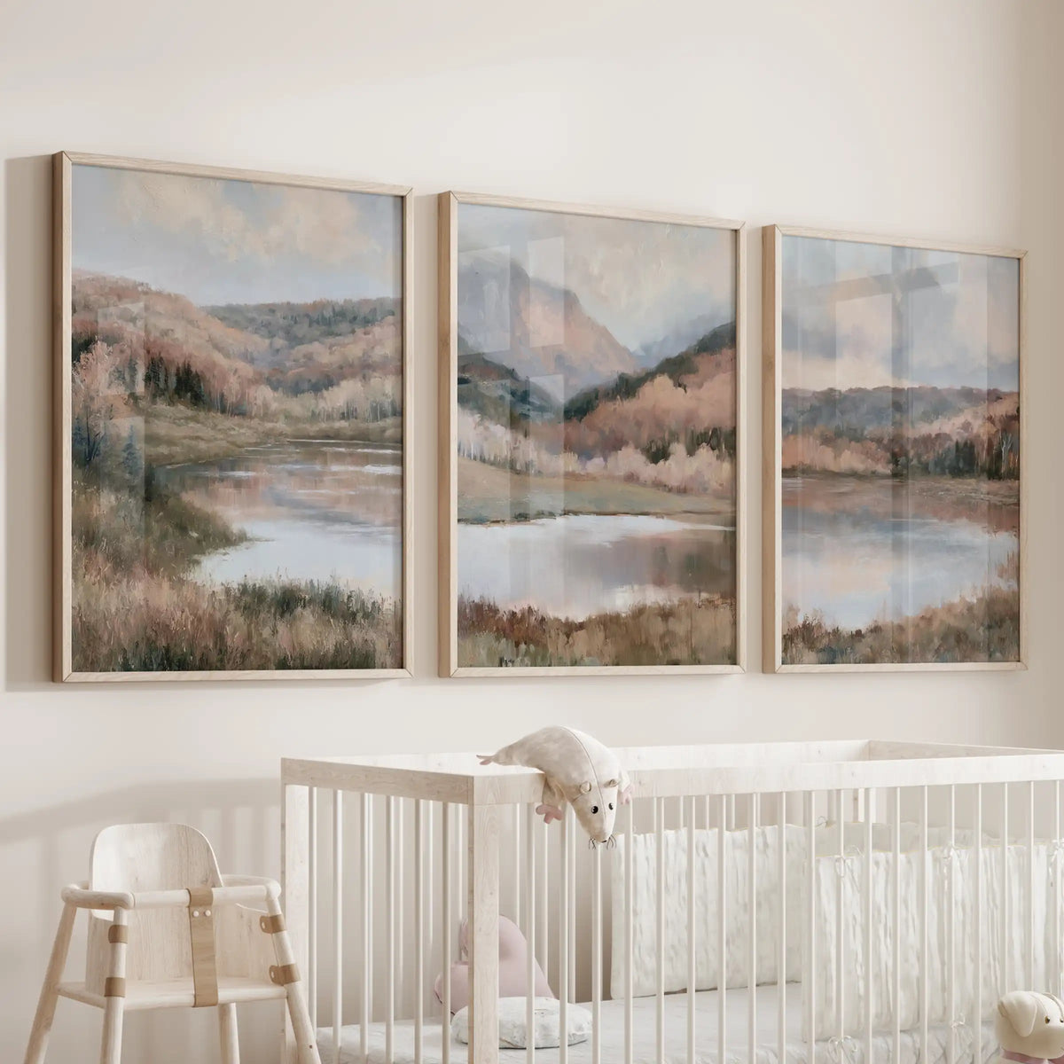 Three art prints of misty forest and distant mountains in natural wood frames float above the cot in the baby’s room with soft, cottage-calm character.