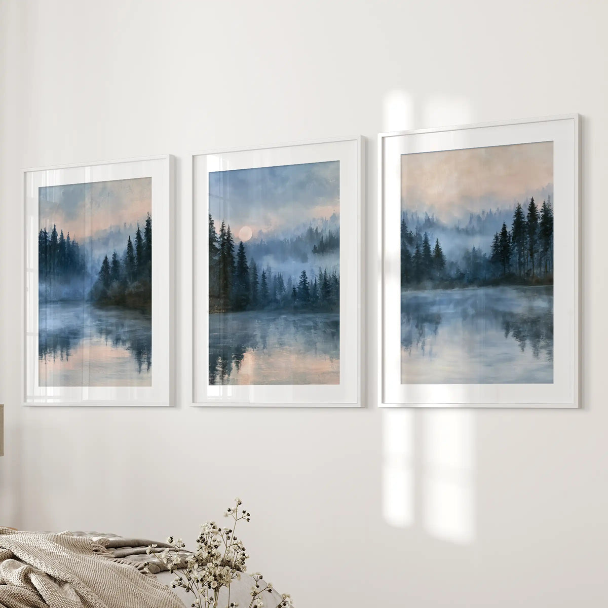 Misty forest lake 3-print wall art set, matted in white frames, lines the bedside wall to cast cool, foggy blues across a restful bedroom.