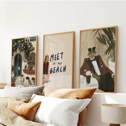 A sun-washed three-piece Mediterranean beach hanging in warm wooden frames brings an easy, relaxed feel above the bed.