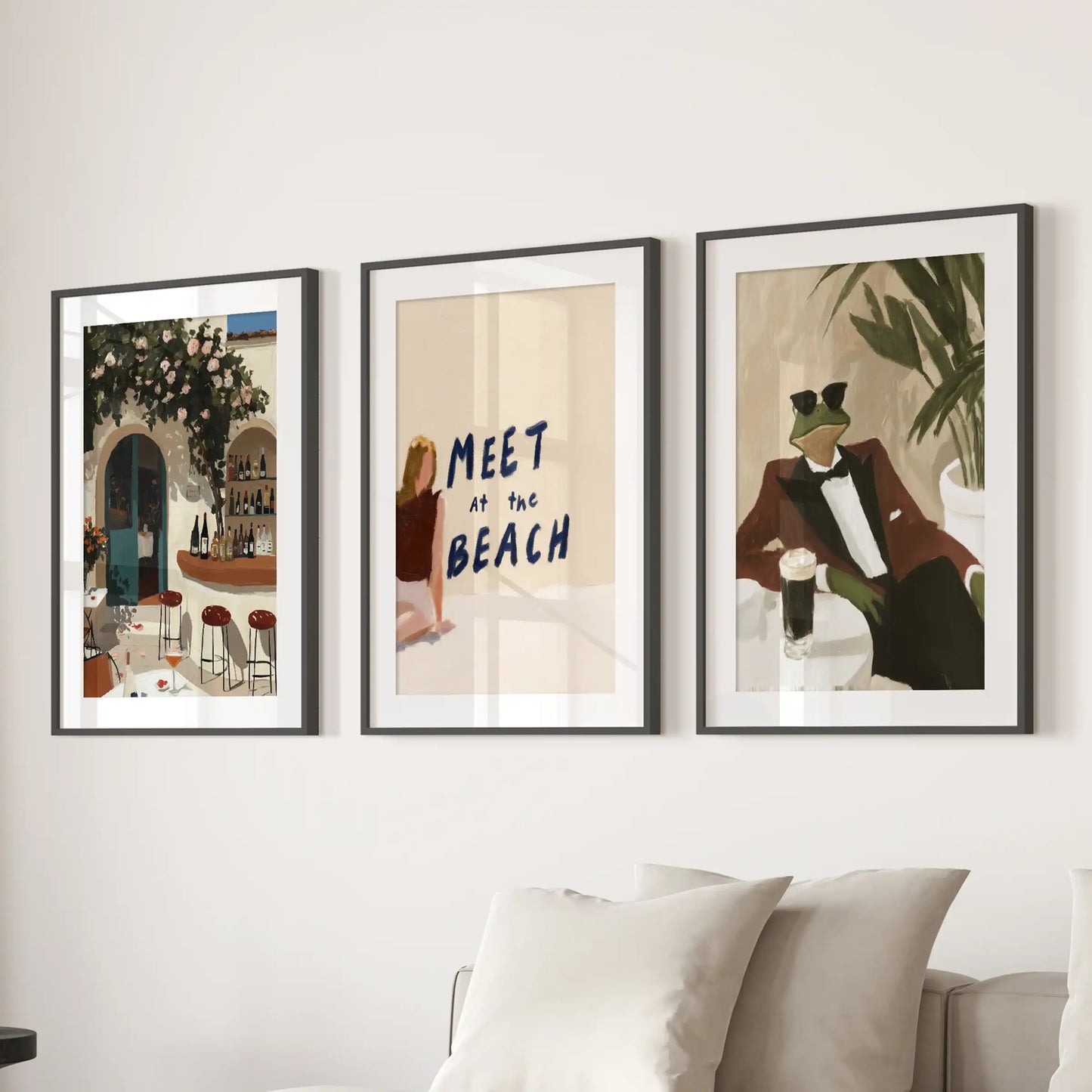 Modern coastal wall art set of 3 with Italian bar, Meet at the Beach and tuxedo frog prints in black frames above the sectional.
