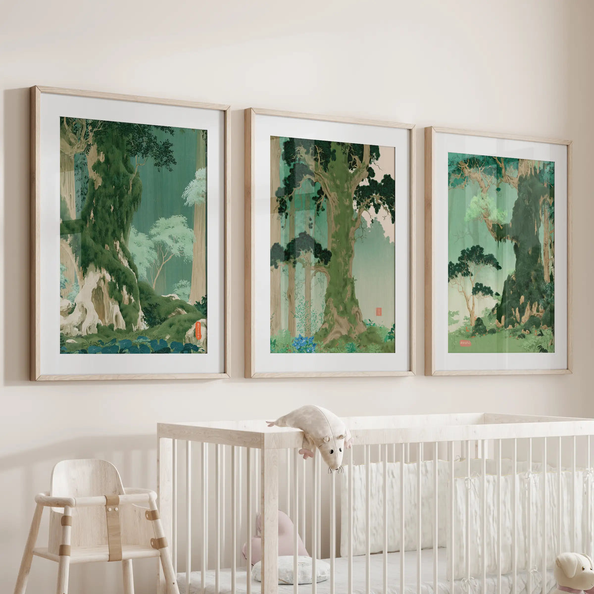 Japanese nature landscape wall art, a three-piece set in light wood matted frames, is displayed over the cot in a baby room.