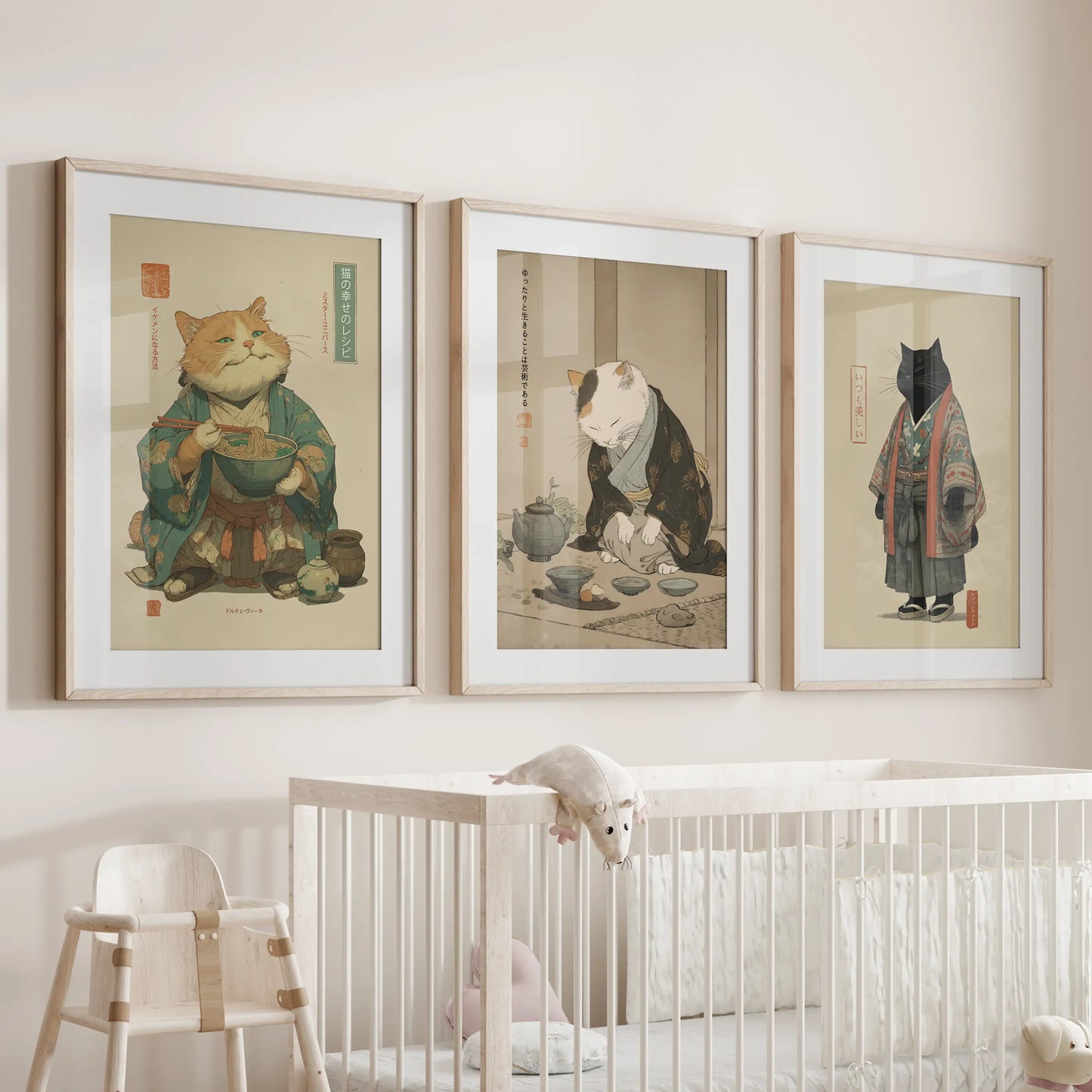 Three oak-framed Japandi cat prints, softly matted, hang above the cot and lend gentle warmth and natural tone to the baby's room.