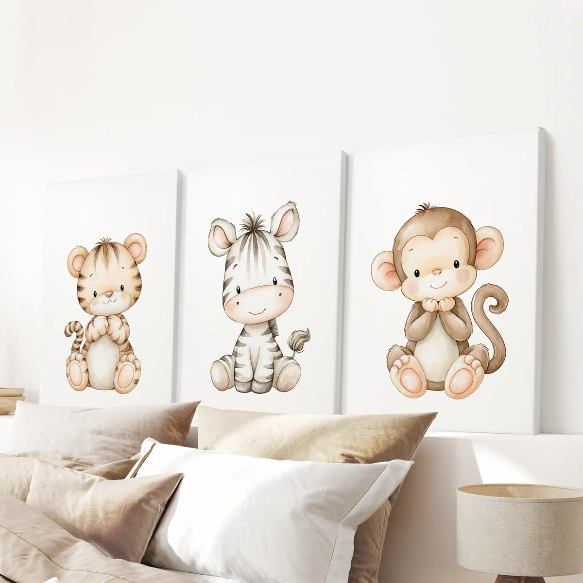 Baby tiger, zebra and monkey artwork is displayed on three canvases above a bed.