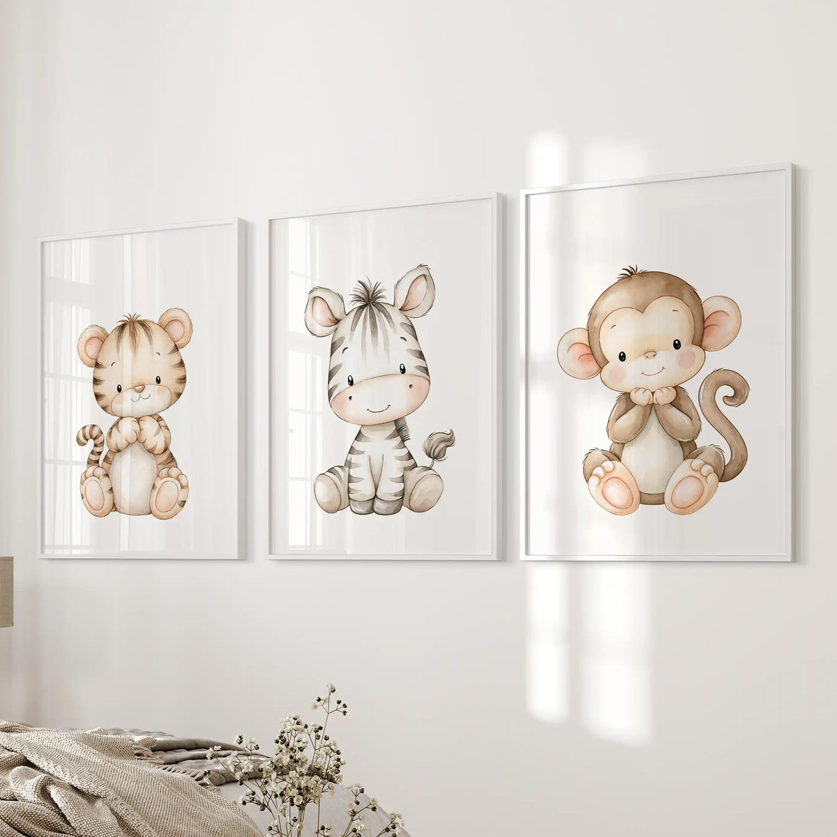 A striped zebra separates a tiger cub from a brown monkey in three white-framed prints beside a bed.