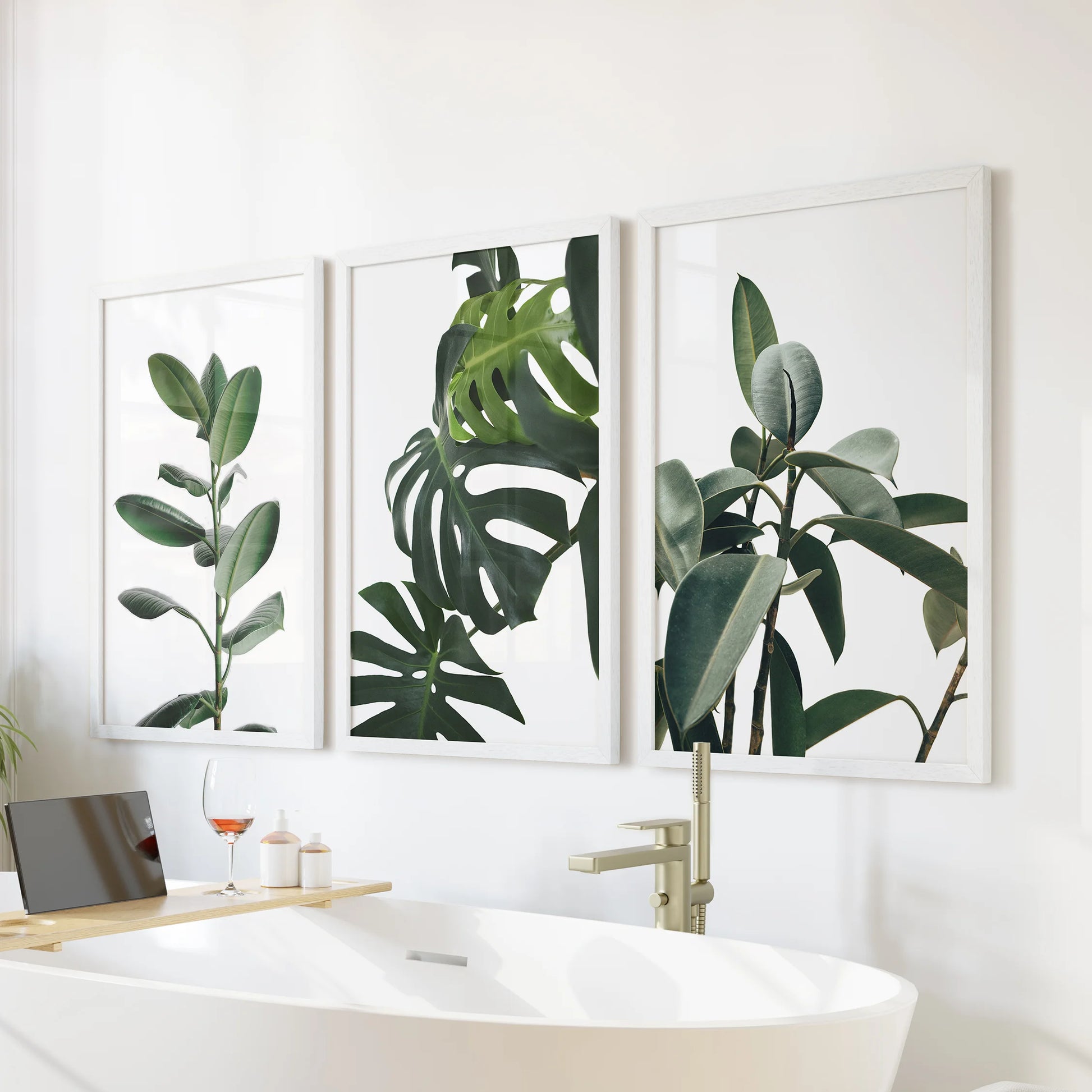 Tropical houseplants, a 3-piece wall art suite in white frames, feels spa-bright in the bathroom, styled above the tub wall for a clean, calming note.