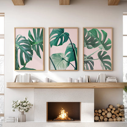 Tropical pink and green foliage 3-piece artwork set, thin wood framed, brings relaxed wall art to the family room, styled neatly over the mantelpiece.