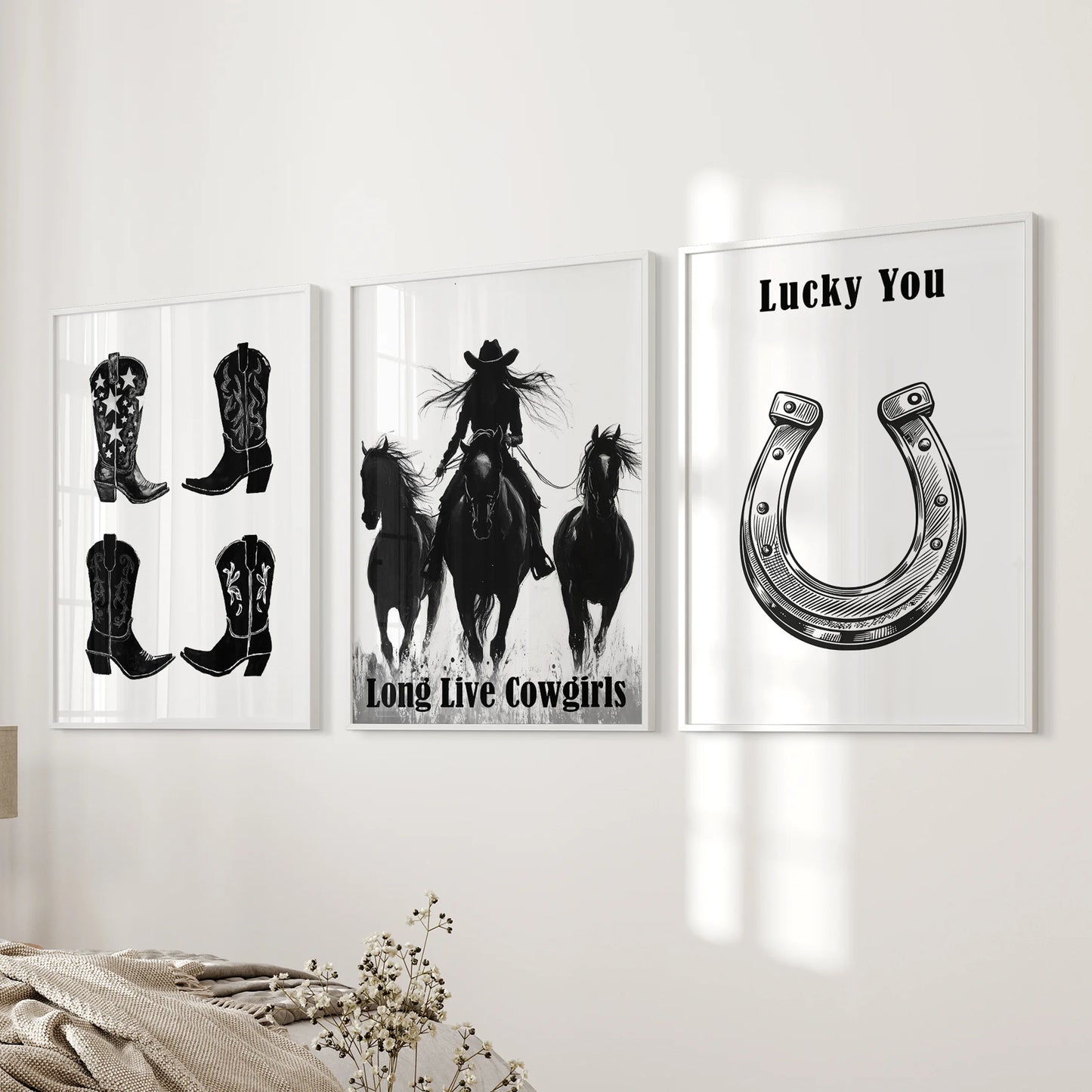 Long Live Cowgirls typography, part of a white-framed gallery wall trio, settles near the bedroom bed wall for a bold yet airy Western accent.