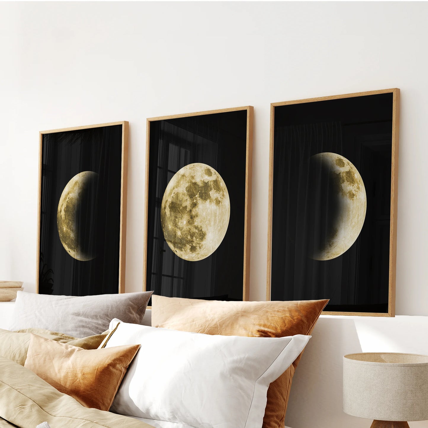 Three oak-framed moon prints create a gold phases triptych over the headboard, centering the bedroom with warm organic style.