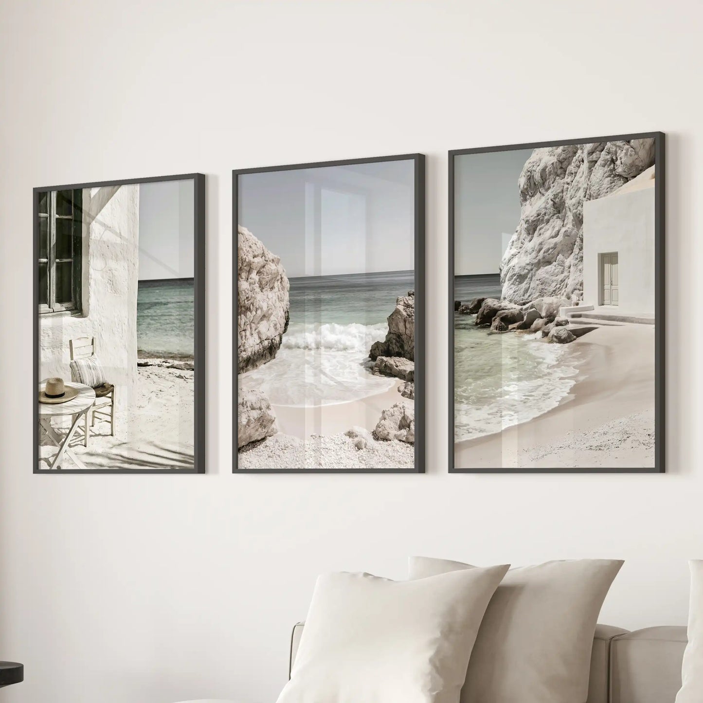 A 3-wall-art set presents Mediterranean coastline vistas in slim black frames, placed over the sofa to fill the sitting room with serene neutral tones.
