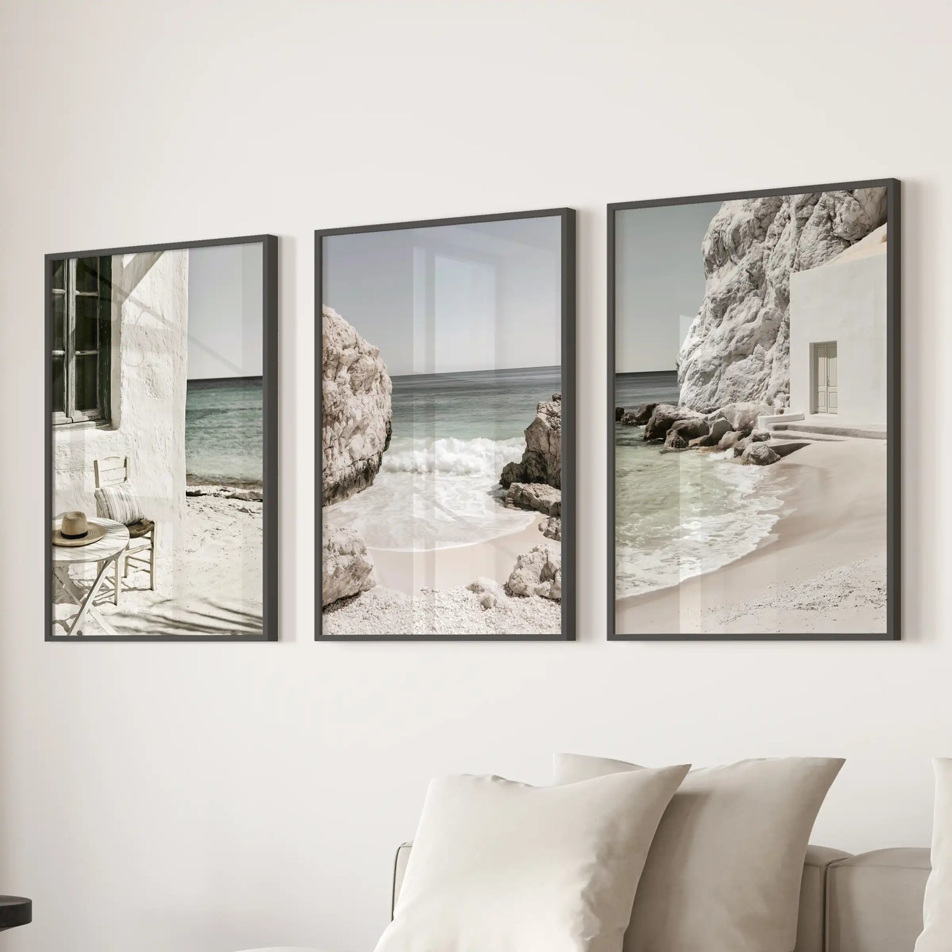 A 3-wall-art set presents Mediterranean coastline vistas in slim black frames, placed over the sofa to fill the sitting room with serene neutral tones.