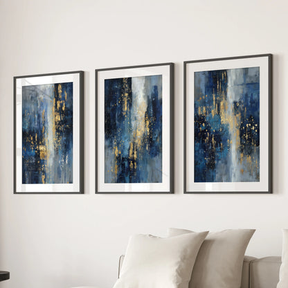 Three framed art prints featuring gold sparkle on deep navy hang above a sectional sofa, adding polished warmth to the lounge.