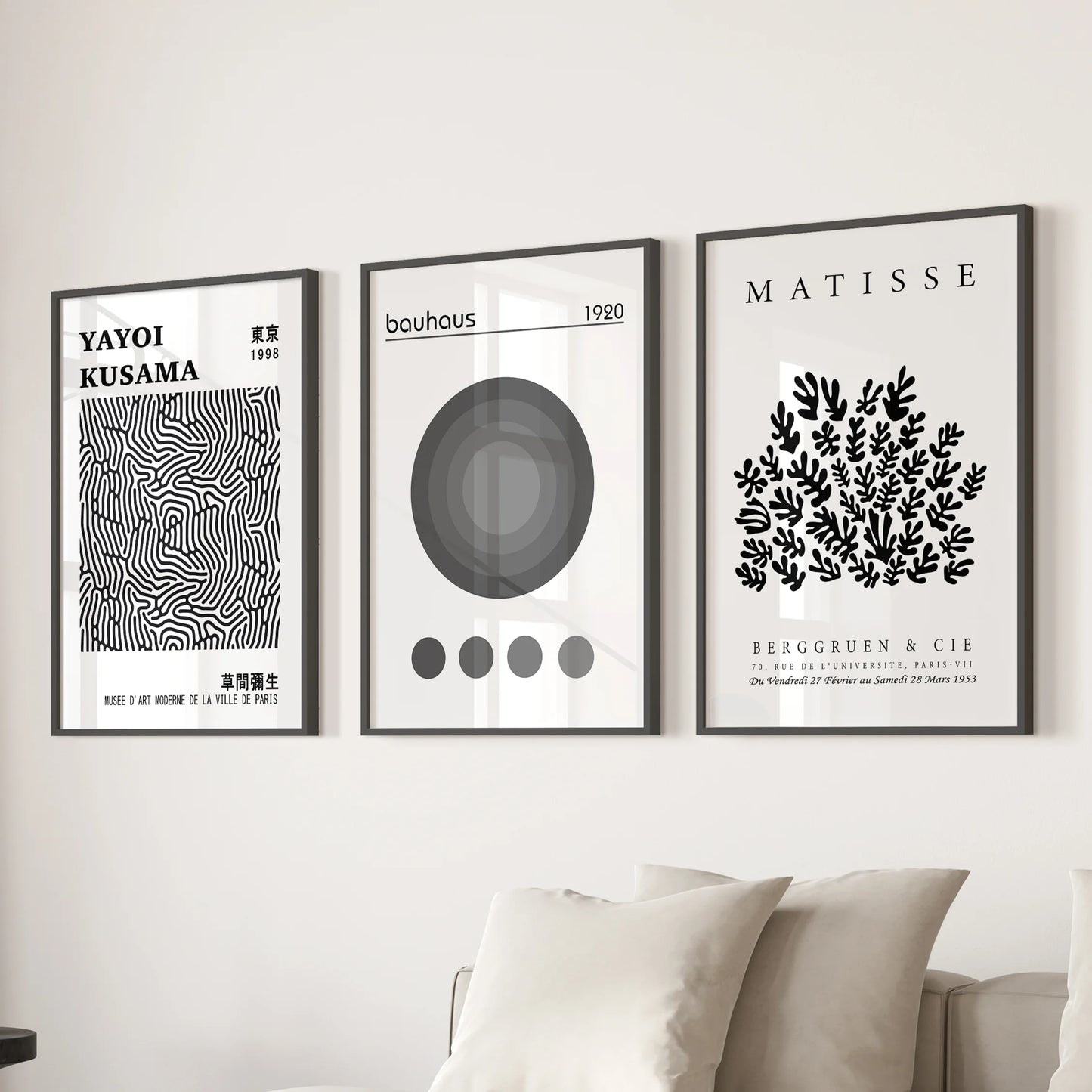 A trio of Matisse-style cut-out prints in black frames form statement wall art behind the couch, styling the living room with bold shapes.