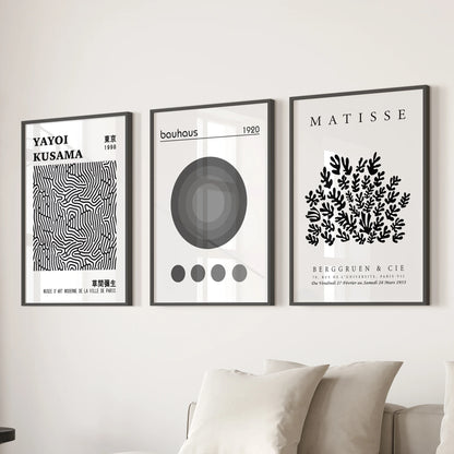 A trio of Matisse-style cut-out prints in black frames form statement wall art behind the couch, styling the living room with bold shapes.