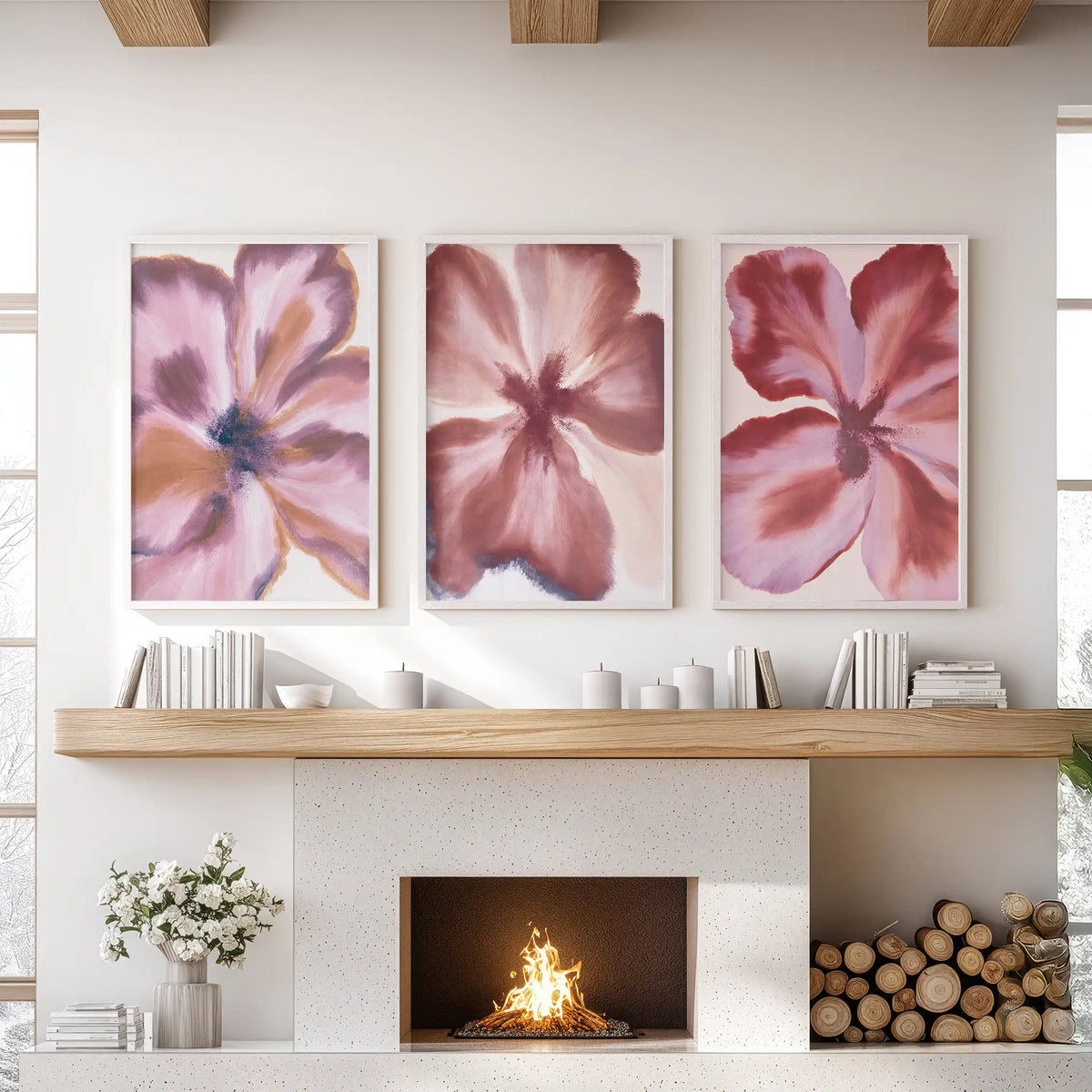 The three white-framed prints above a fireplace show broad burgundy petal shapes, with mauve and dusty pink highlights.