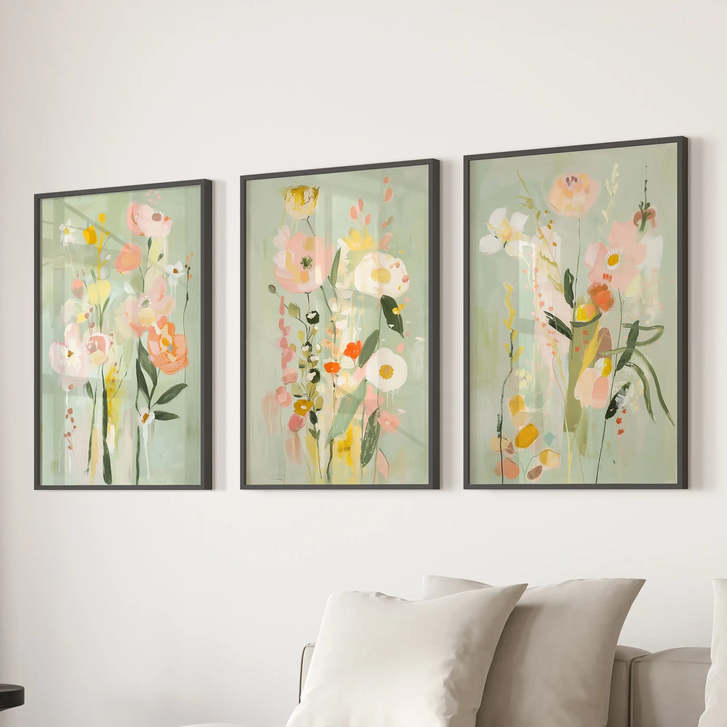 Pink and green florals, a three-print poster set, appear as black-framed wall art behind the sofa in the lounge.