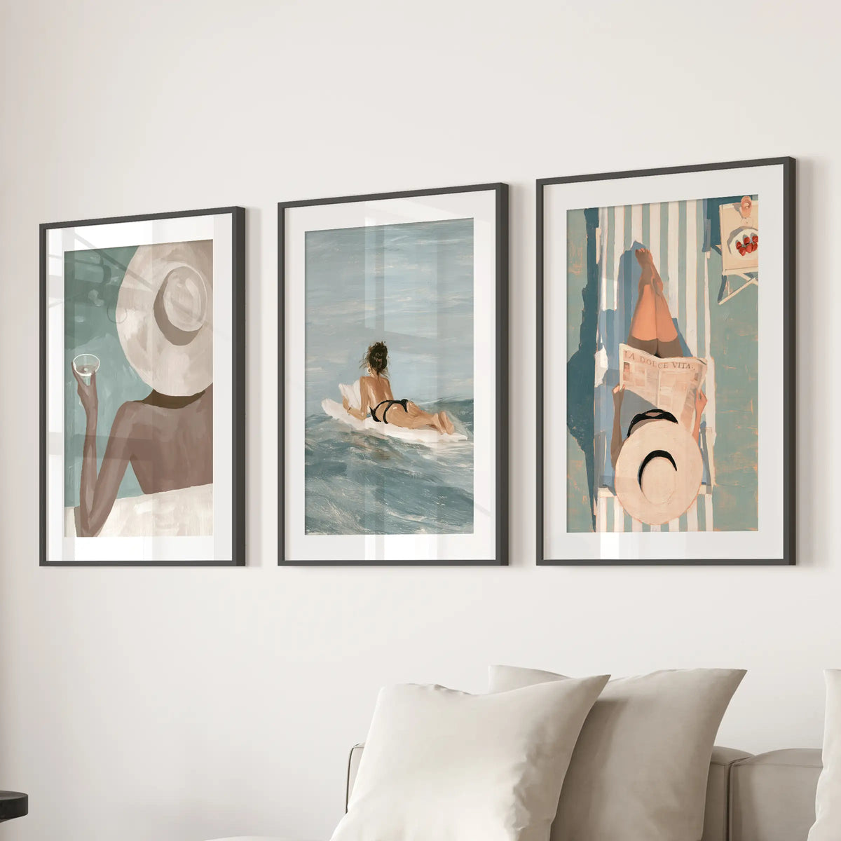 Mediterranean resort three-piece picture set in black frames with white mats, displayed behind a living room sofa.