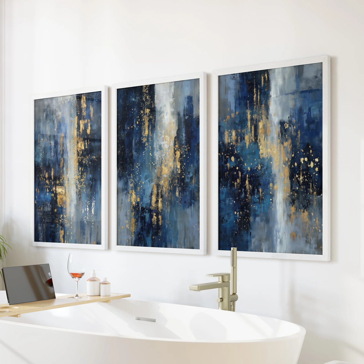 Metallic gold on indigo abstract swirls, three white-framed art prints, arranged above the tub to lend a serene, gallery feel to the bathroom.