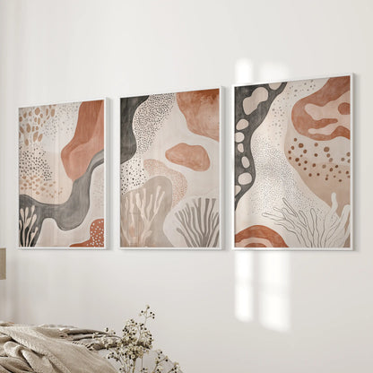 Three white-framed boho prints rest beside the bed, echoing a mid-century spirit with clean, balanced shapes.