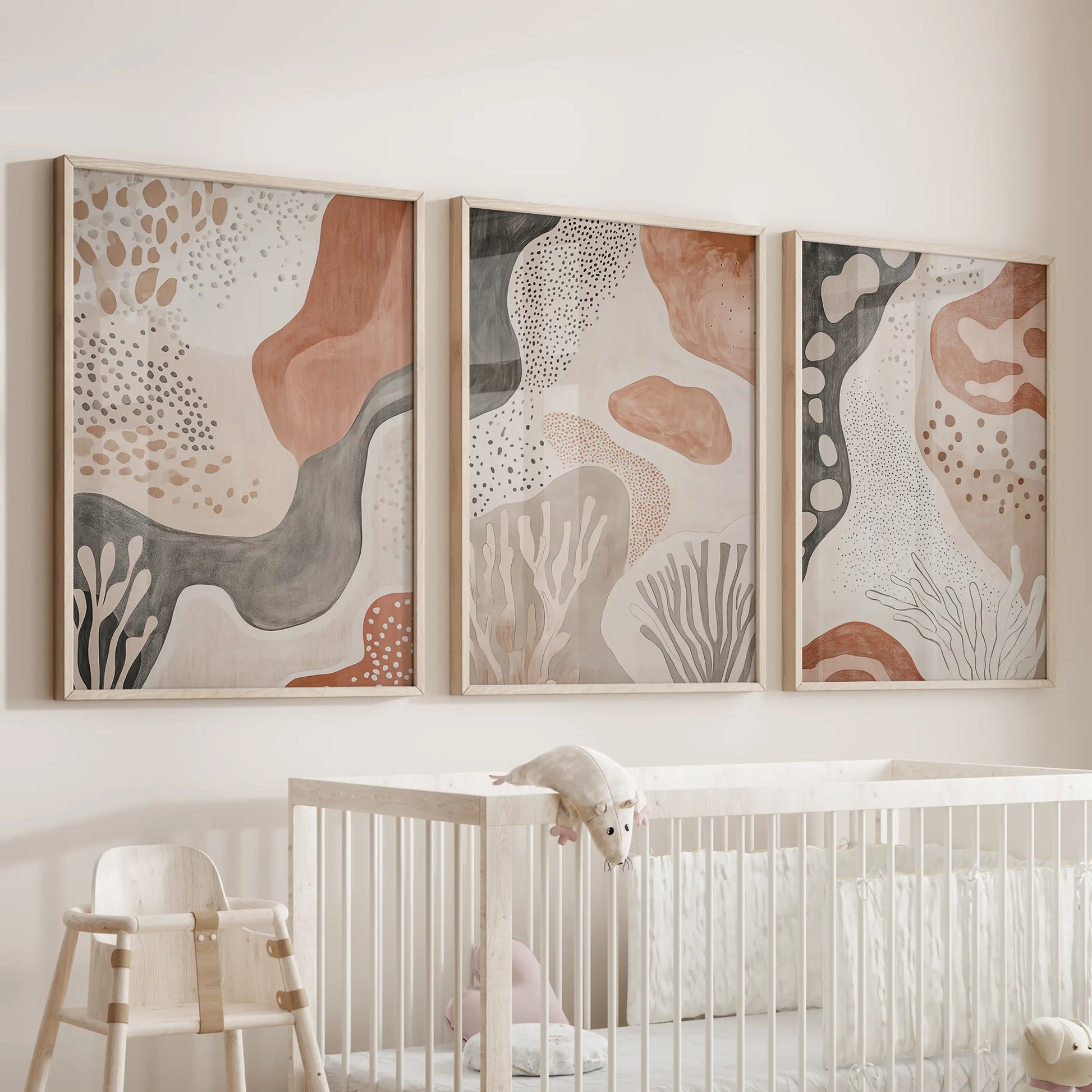 A 3-piece oak-framed poster set with boho abstract shapes hangs above the crib, bringing gentle sun-washed color to the nursery.