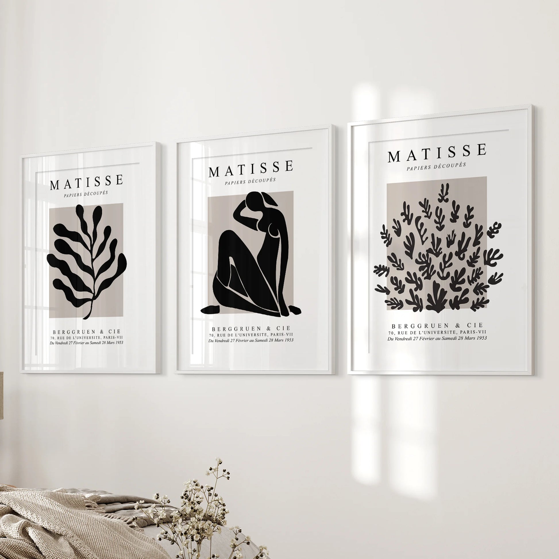 Henri Matisse style prints, a 3-piece wall art set in white matted frames, hang on the wall next to the bed.