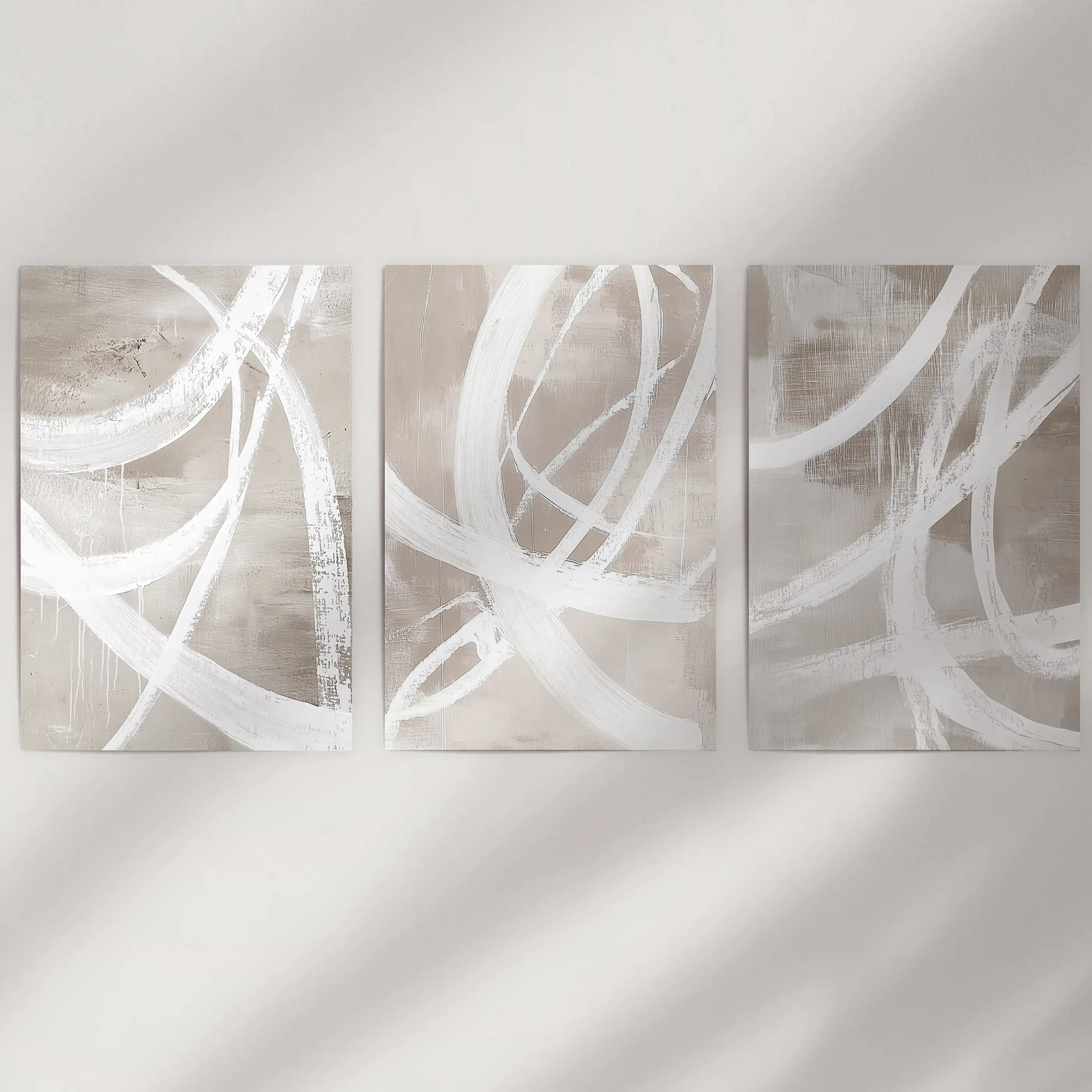 Unframed posters with minimal color-blocking stand crisp and modern across a blank wall, forming a clean three-poster display.