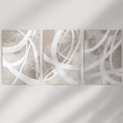 Unframed posters with minimal color-blocking stand crisp and modern across a blank wall, forming a clean three-poster display.