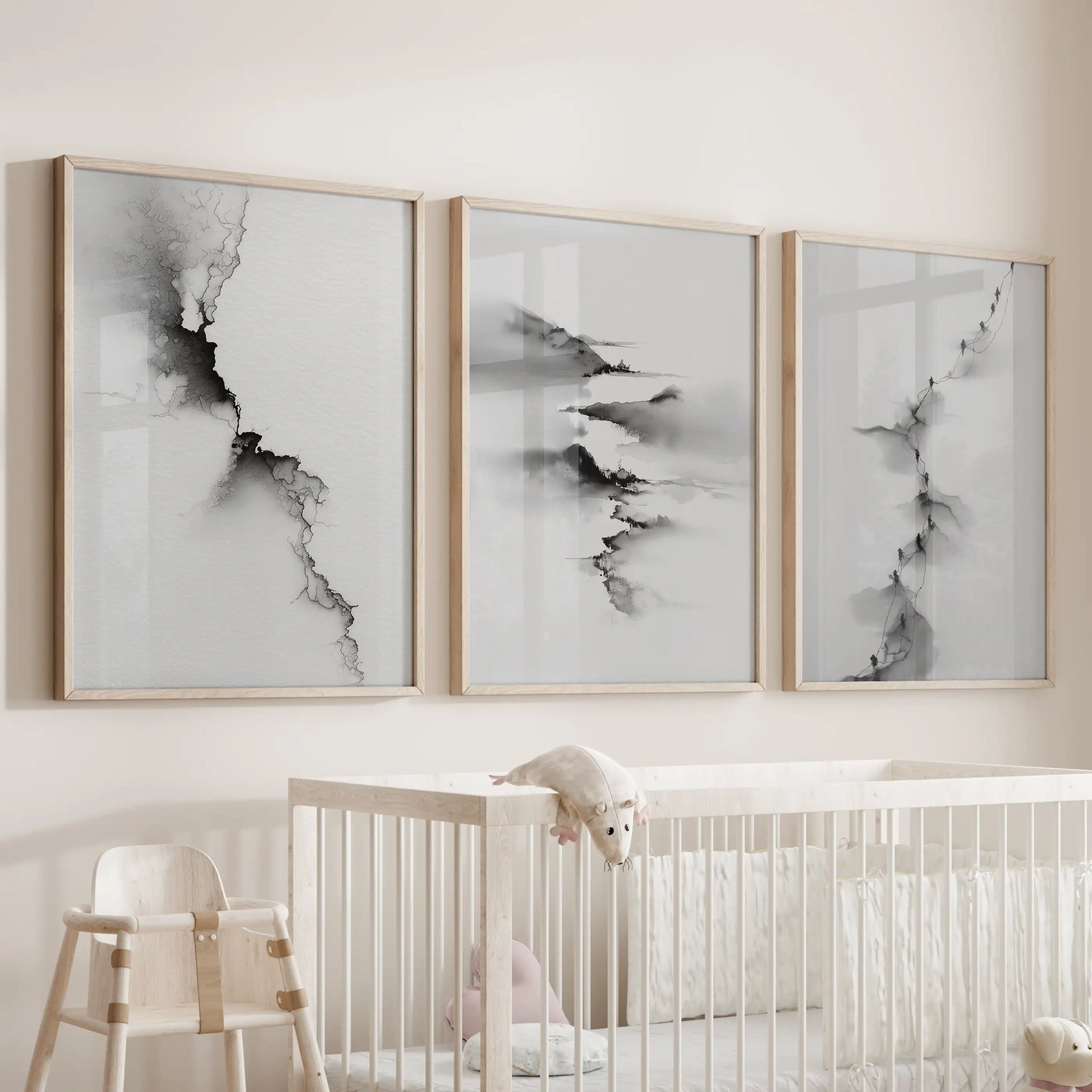 Modern monochrome scenery, a set of three wall art prints in natural wood frames, is positioned above the bassinet to soothe the nursery.