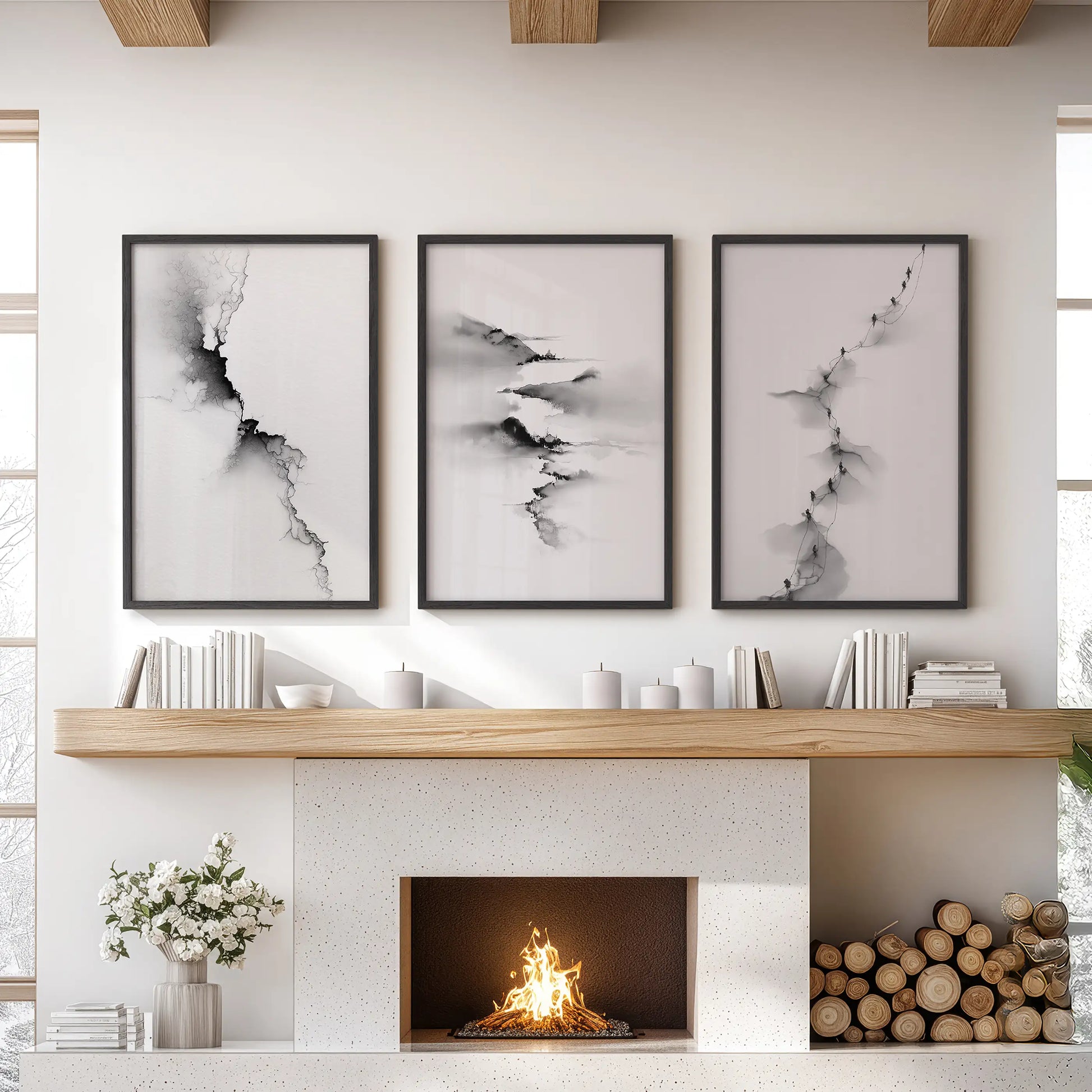 Black-and-white abstract landscape wall art, three-piece set, in slim black frames, arranged above the mantel to ground a modern lounge.
