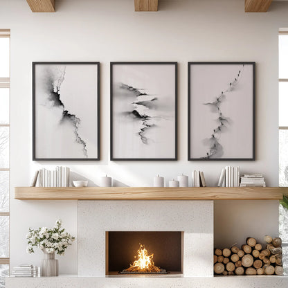 Black-and-white abstract landscape wall art, three-piece set, in slim black frames, arranged above the mantel to ground a modern lounge.