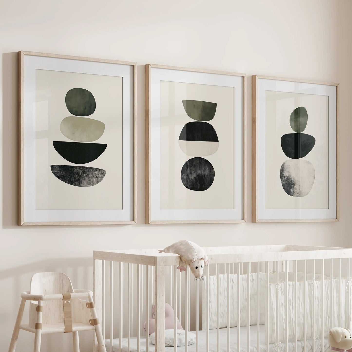 A 3-print series of earth-tone geometry in light wood frames with mats rests above the baby’s cot, warming the nursery with gentle color.