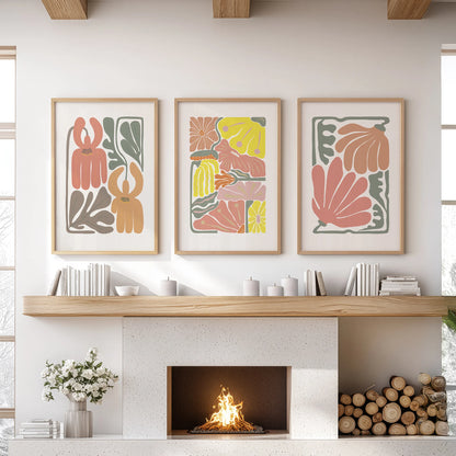 Three minimalist floral artworks in warm wooden frames rest over the sitting-room mantel, giving a polished, modern botanical look.