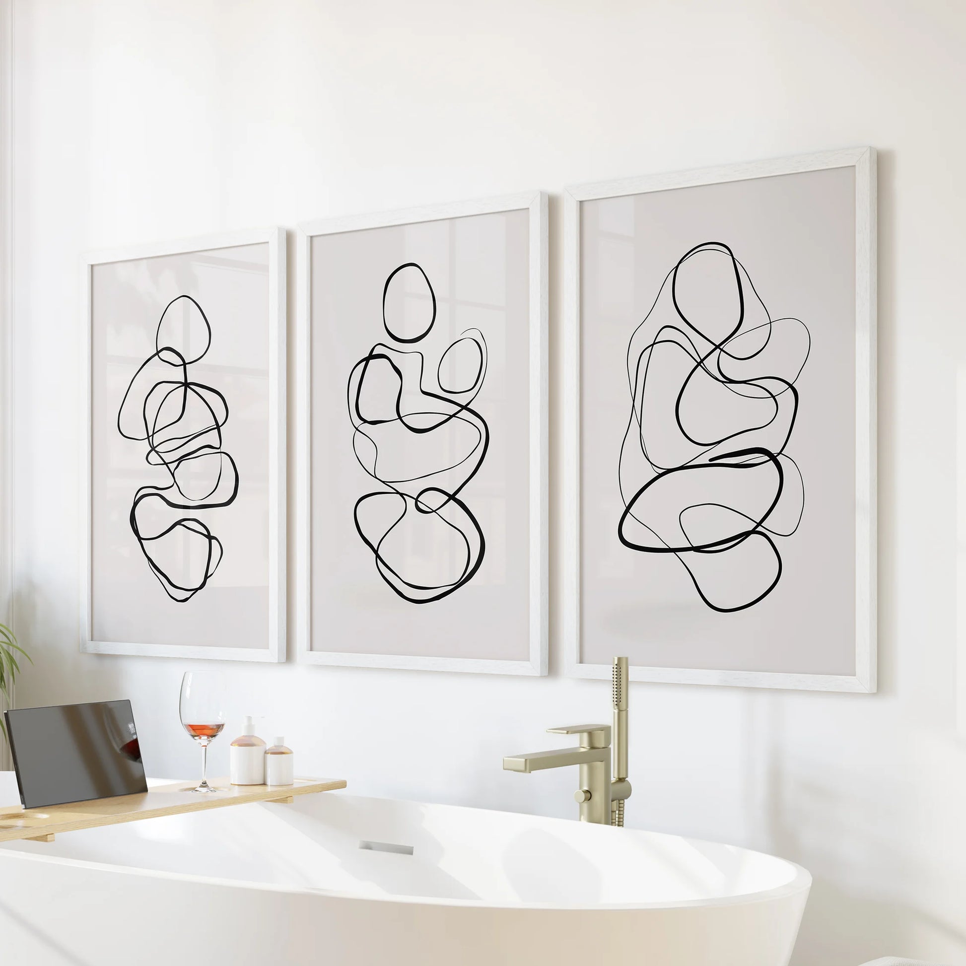 Contemporary line sketches, a set of three art prints, arrive white framed for the bathroom and hang serenely over the bathtub.