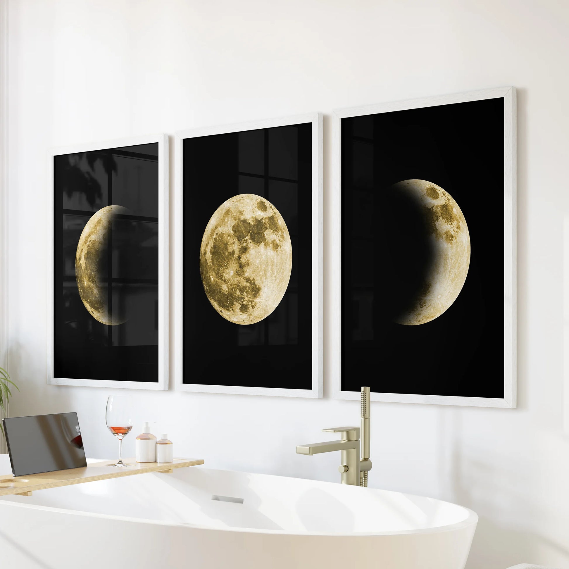 Framed wall decor in crisp white shows a gold moon triptych, the three-print set resting above the bath and lending a calm minimalist mood.