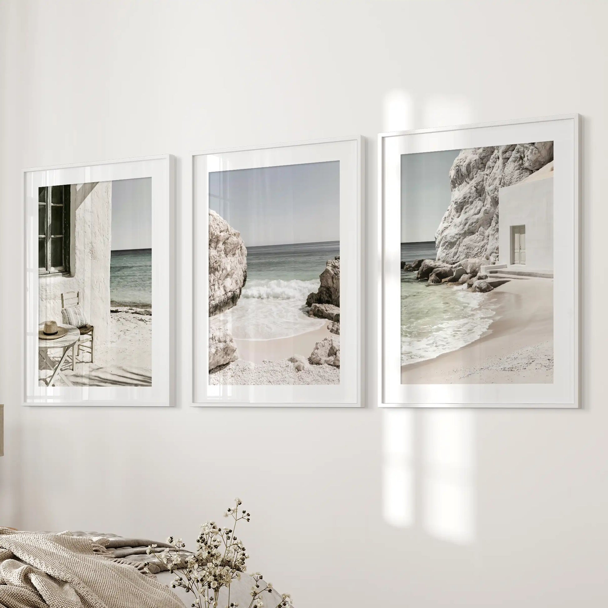 Minimalist ocean scenes, set of 3 posters in white matted frames, land on the wall beside the bed to keep the bedroom airy and composed.