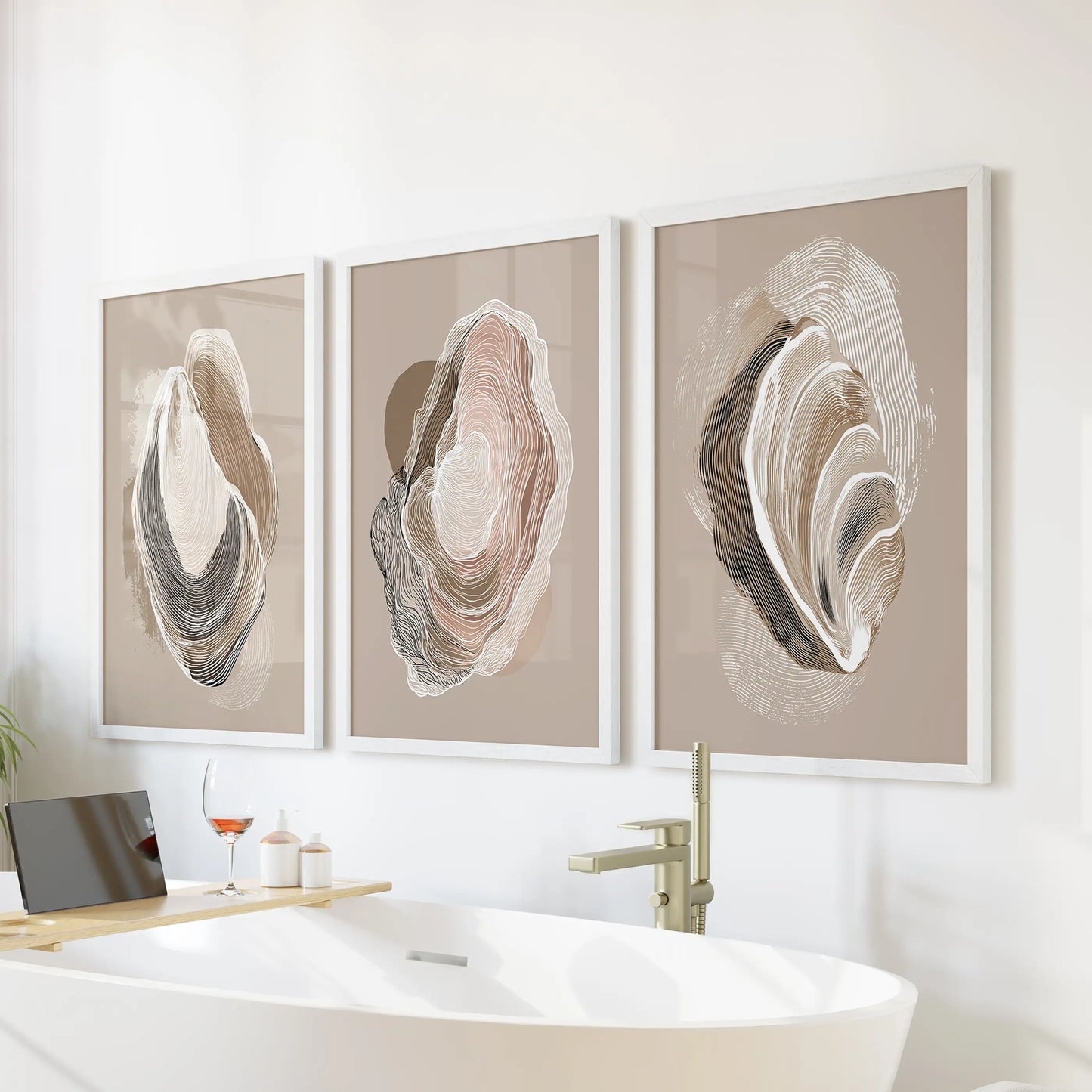 Wabi-sabi oyster line art, a 3-print wall set in white frames, floats above the bath to freshen the bathroom with soft, minimalist seaside tones.