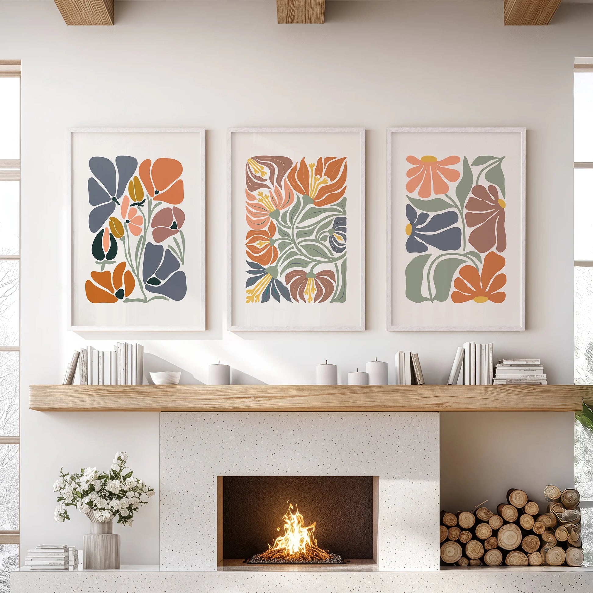 White-framed vintage floral art in a composed set of three centers the family-room hearth with warmth and simple negative space.