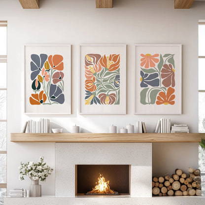 White-framed vintage floral art in a composed set of three centers the family-room hearth with warmth and simple negative space.
