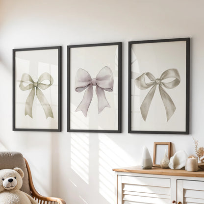 Minimalist ribbon art, a wall-hanging set of three, sits above the playroom dresser in slim black frames, keeping the palette calm while adding a sweet bow motif.
