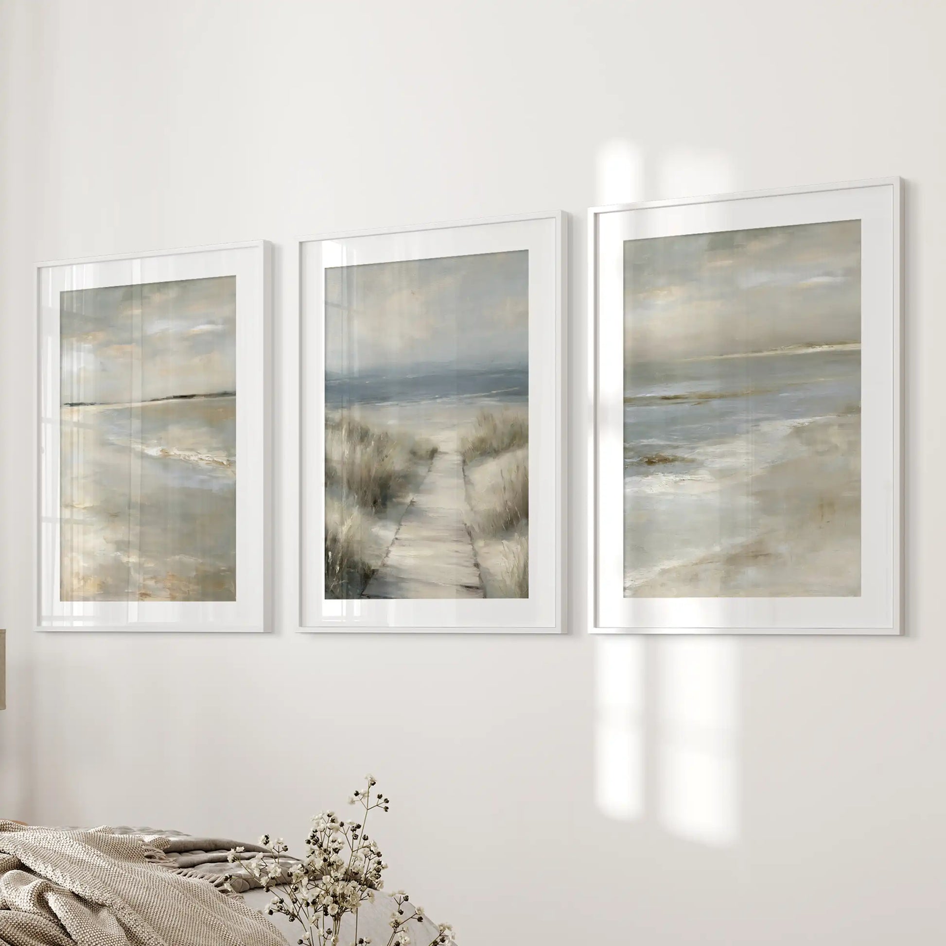 Dune grass shoreline set of three wall art prints with white mats and frames lends a restful, seaside feel across the bedroom wall.