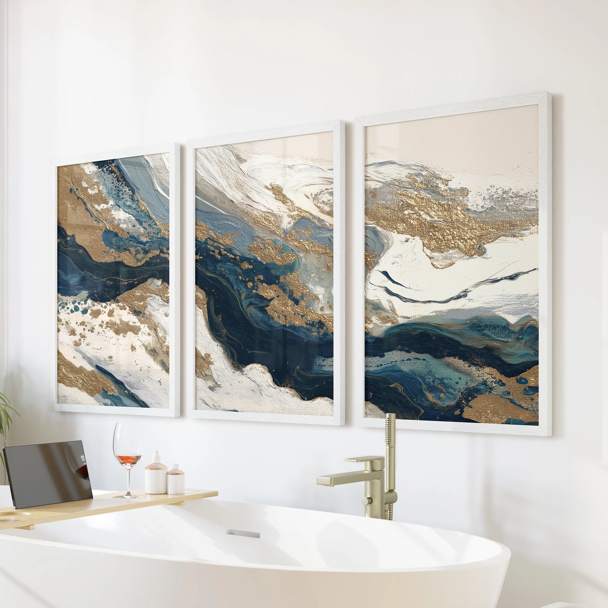 Navy blue and gold abstract brushstrokes, a three-panel wall art set, hangs above the tub in the bathroom in white framed prints for spa-calm color.