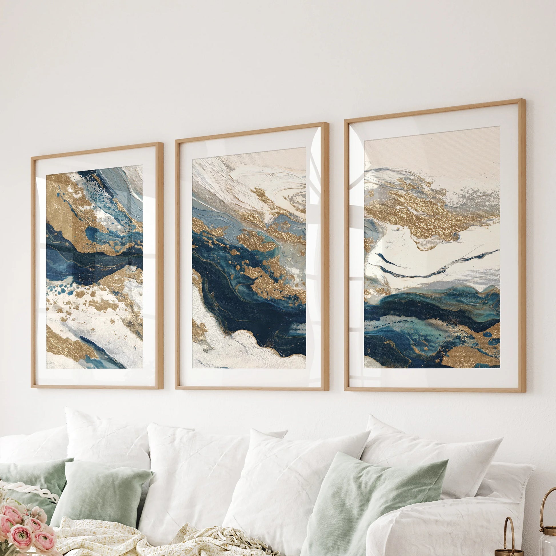 A wall hanging set of three abstract prints spans the space above the living room couch, their oak frames and soft mats bringing earthy balance.