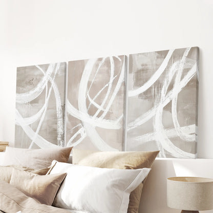 Three neutral beige canvas prints form a subtle wall display above the headboard, completing the bedroom’s cohesive focal point.