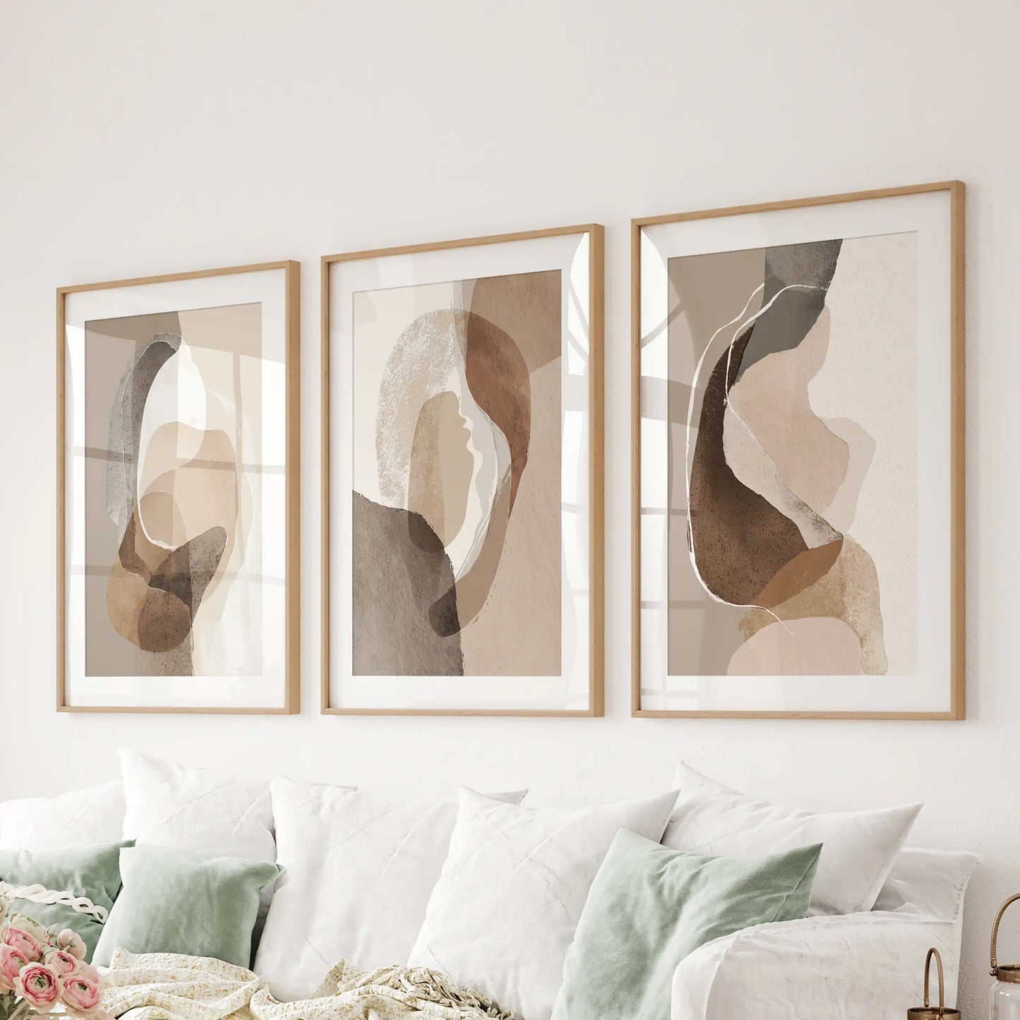 Wall art set of three boho abstract prints matted in oak stretches over the family-room couch to anchor the space in warm neutrals.