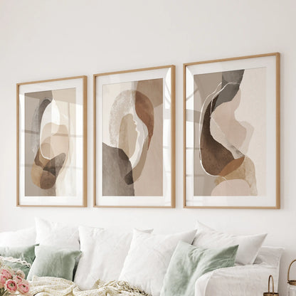 Wall art set of three boho abstract prints matted in oak stretches over the family-room couch to anchor the space in warm neutrals.