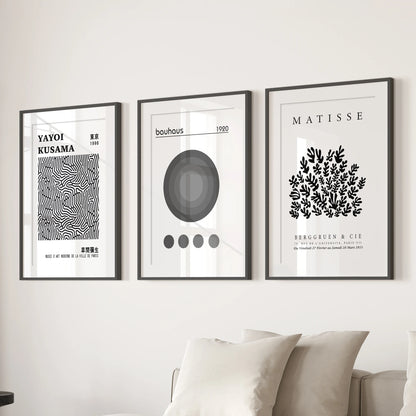 Gallery wall prints-three framed exhibition posters with mats-hang over the lounge sofa for a balanced, curated display of modern art.