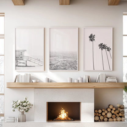 This three-print wall art set of an ocean shoreline spans the lounge in white frames, creating a serene focus above the hearth.