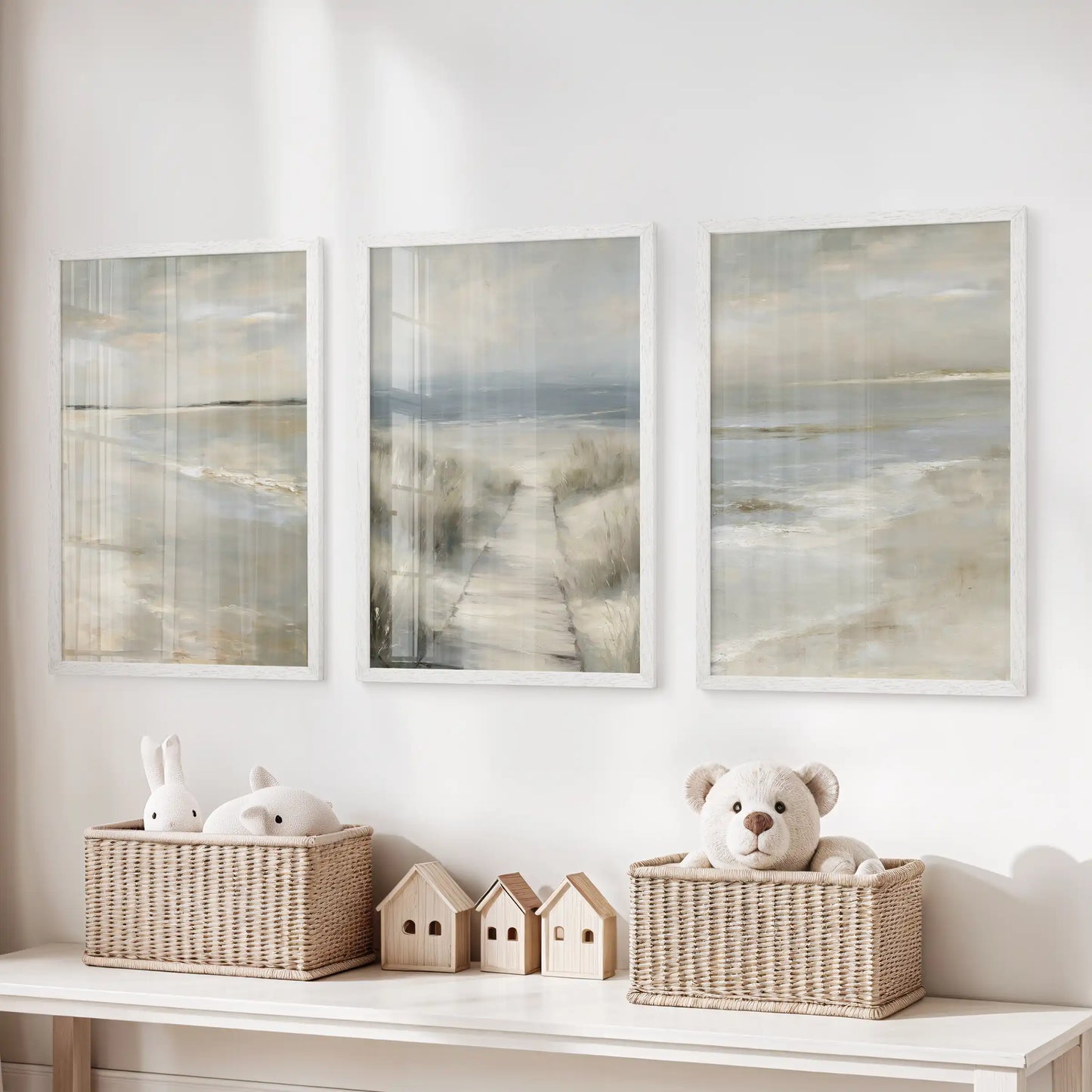 White-framed coastal art prints, a set of three showing soft sand textures, line above toy storage for a soothing beachy touch in the kids’ room.