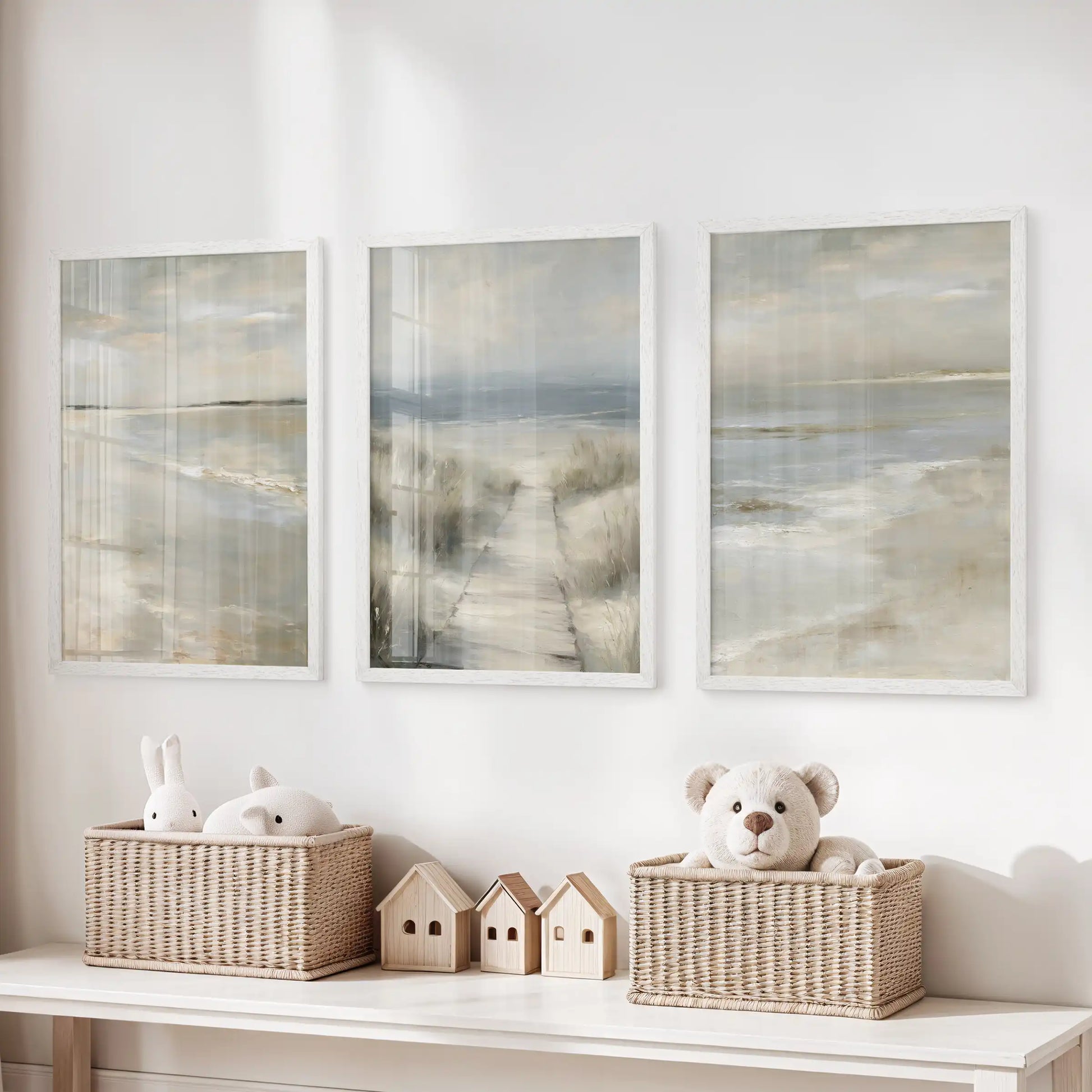 White-framed coastal art prints, a set of three showing soft sand textures, line above toy storage for a soothing beachy touch in the kids’ room.