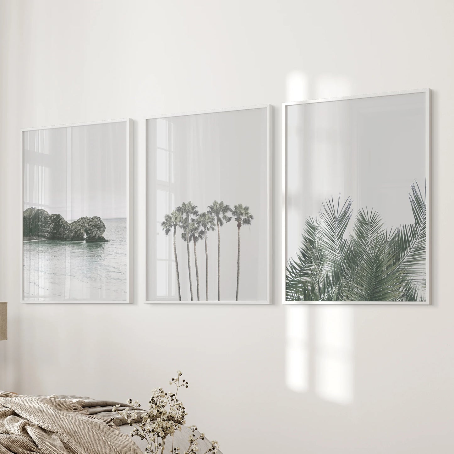 Three white-framed wall prints of a tropical shoreline freshen the bedroom décor, creating a calm, beachy mood across the wall.