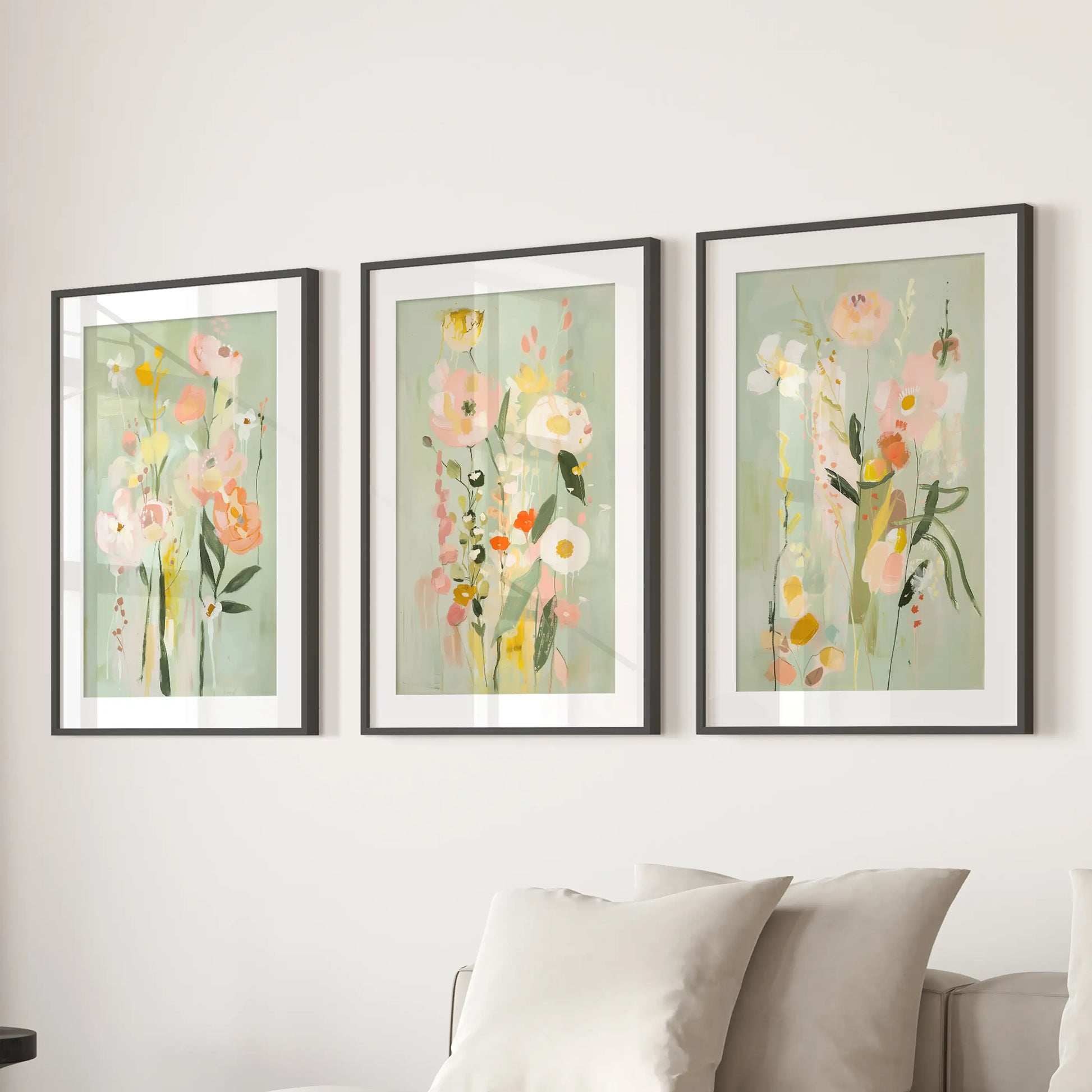 Three matted black-framed botanical prints bring a fresh spring feel to the lounge wall above the sectional sofa.